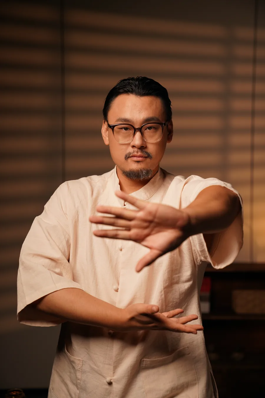 Master Lao facing forward, one palm pressing out at chest height.